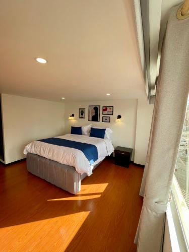 a bedroom with a large bed and a window at Hotel Embajada 44 in Bogotá