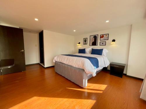 a bedroom with a large bed and a wooden floor at Hotel Embajada 44 in Bogotá