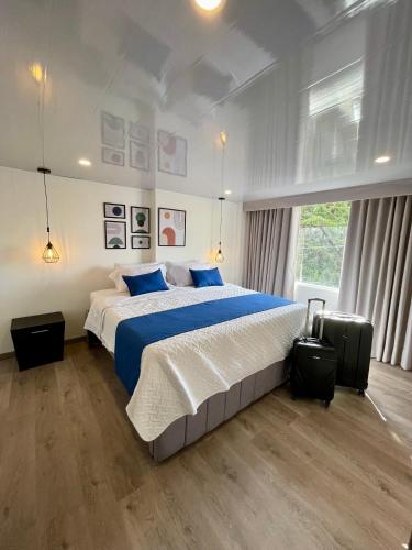 a large bedroom with a large bed with blue pillows at Hotel Embajada 44 in Bogotá