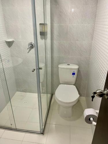 a bathroom with a toilet and a glass shower at Hotel Embajada 44 in Bogotá