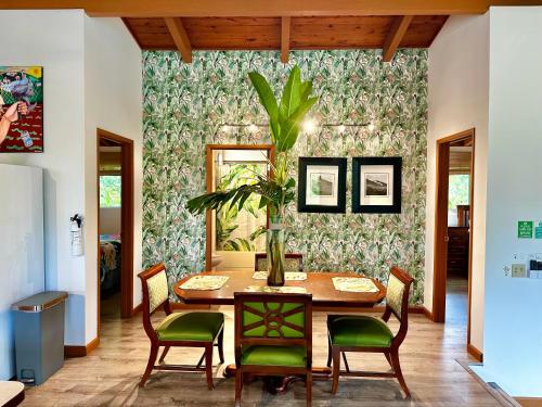 a dining room with a table and green chairs at Puna Zen Botanical Garden Retreat in Keaau