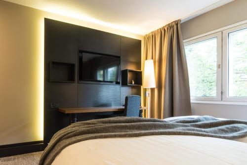 a bedroom with a bed and a lamp at Lapland Hotels Oulu in Oulu