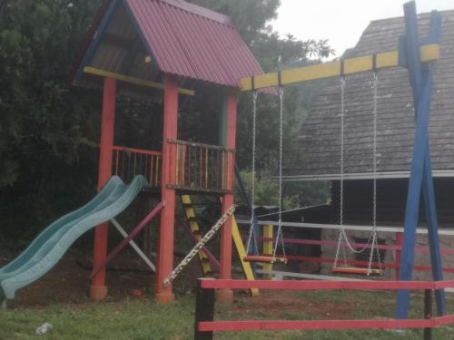 un parque infantil con tobogán y una casa en Vikend kuća Nikolić, en Leskovac