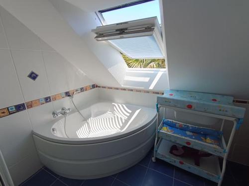 La salle de bains est pourvue d'une baignoire et d'une lucarne. dans l'établissement ty koz, à Erdeven