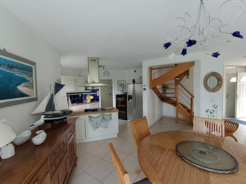 une cuisine avec une table en bois et une cuisine avec un escalier dans l'établissement ty koz, à Erdeven