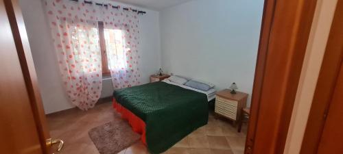a small bedroom with a bed and a window at Casa vacanza 70 mq in Valledoria