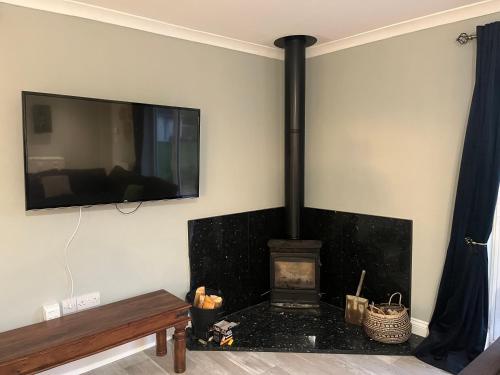 a living room with a fireplace with a tv on the wall at The Apartment at Woodside in Stockton-on-Tees