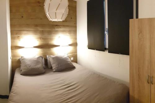 un lit dans une chambre avec deux oreillers dessus dans l'établissement CosyLary T3 Pic Lumière 3 étoiles 5 diamants et terrasse avec vue sur les montagnes, à Saint-Lary-Soulan