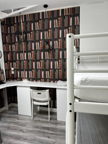 une chambre avec un lit superposé et un mur de livres dans l'établissement Chez Mia Paris, à Paris