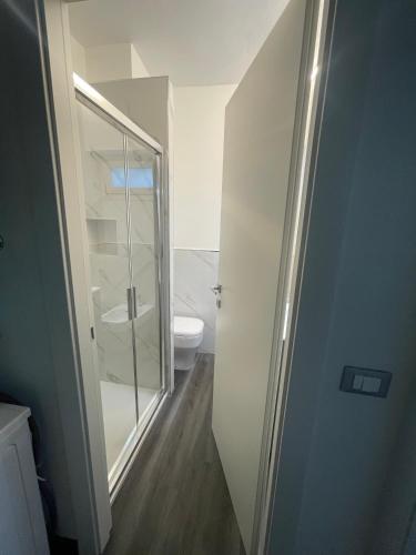 baño con aseo y puerta de ducha de cristal en La Casetta, en Ventimiglia