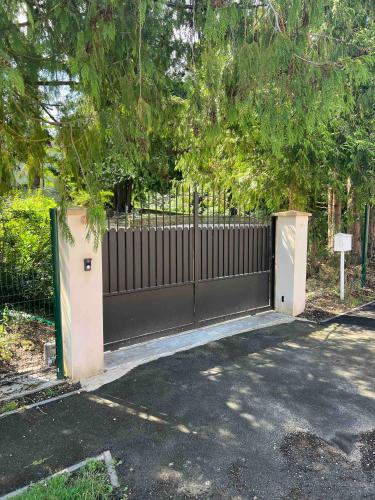 a black fence with a gate in a driveway at Villa champenoise, La Psière in Courthiézy