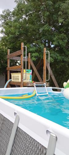 une petite piscine avec une balançoire et une chaise dans l'établissement Chambre privée calme,campagne,étape,déplacement pro,abri moto vélo,parking, à Vaux-sur-Vienne