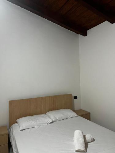 a bed with white sheets and two towels on it at Guesthouse Ale&Ale in Tale