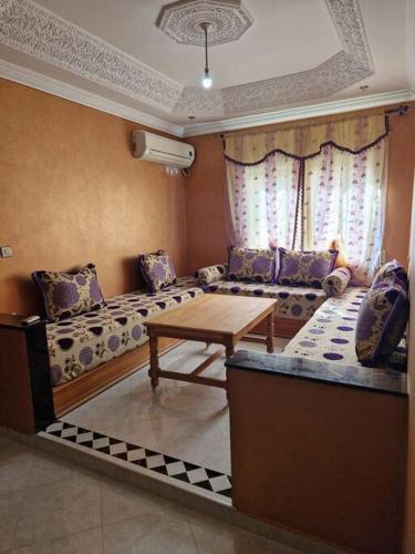 a living room with a couch and a table at Logement climatisé proche de Fès in El Harmiine