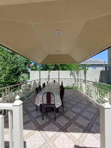 a patio with a table and chairs under a roof at Quba Family Garden House in İkinci Nügǝdi