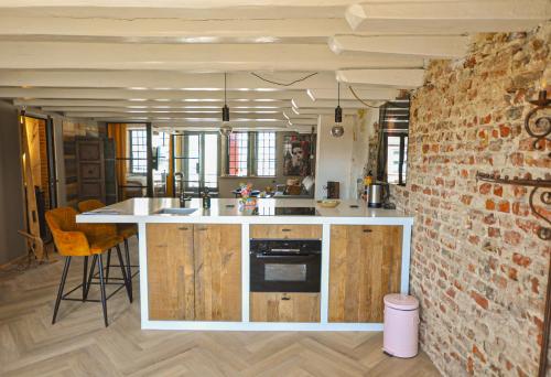 a kitchen with a counter and a brick wall at Anno 1706 apartments in Middelburg
