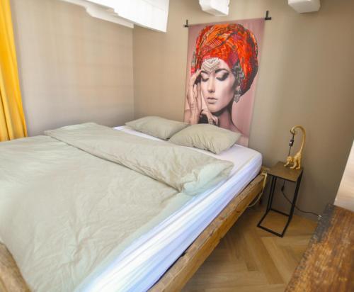 a bedroom with a bed with a painting of a woman at Anno 1706 apartments in Middelburg