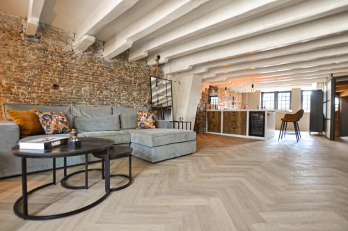 a living room with a couch and a table at Anno 1706 apartments in Middelburg