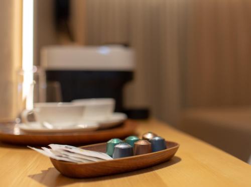 a wooden bowl filled with dominoes on a table at XULOS Rooms & Suites in Peñíscola