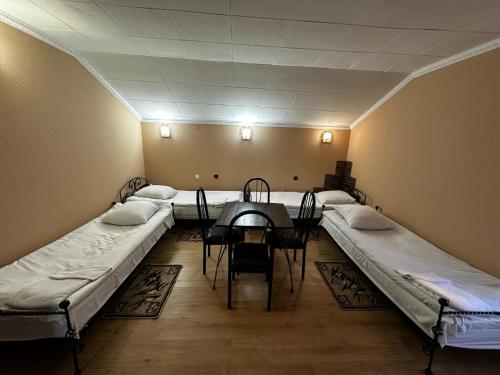a room with two beds and a table in it at Motel Ararat in Rava-Rusʼka