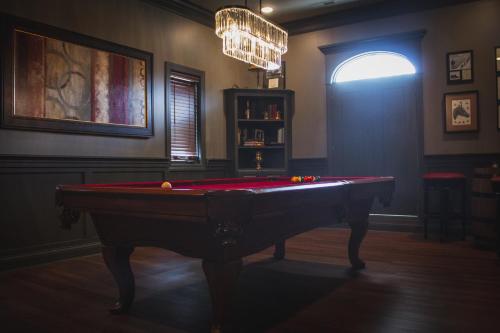 a room with a pool table and a chandelier at The Respite - Bed and Breakfast in Paducah