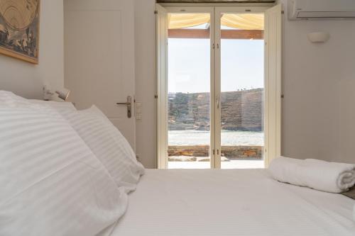 a bedroom with a white bed with a window at Gaia & Thalassa Villa Orionas in Otziás