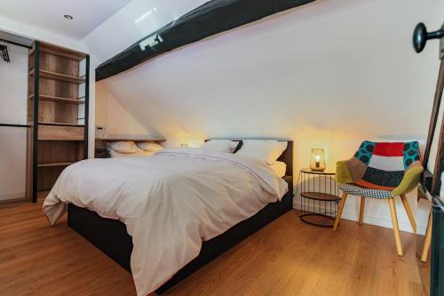 a bedroom with a large bed and a chair at Charmant appartement proche DisneyLand in Bussy-Saint-Georges