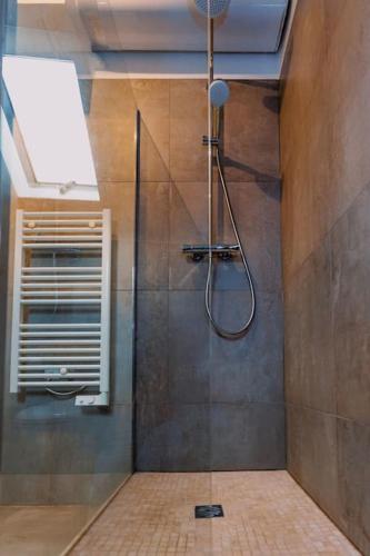 une salle de bain avec une douche avec une porte vitrée dans l'établissement Charmant appartement proche DisneyLand, à Bussy-Saint-Georges