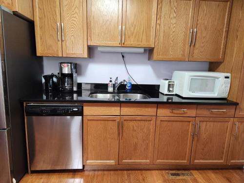 a kitchen with wooden cabinets and a sink and a microwave at Gateway Place in Winnipeg