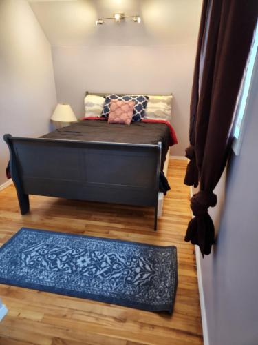 a small bedroom with a bed and a blue rug at Gateway Place in Winnipeg