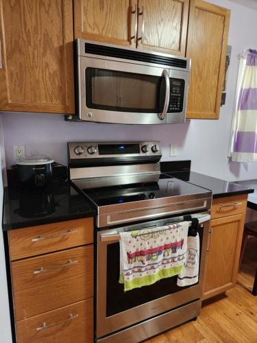 a kitchen with a stove top oven with a microwave at Gateway Place in Winnipeg