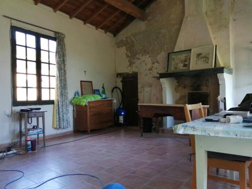 a living room with a fireplace and a table at Mas Ferrieres Saint Laurent sud in Saint-Laurent-le-Minier