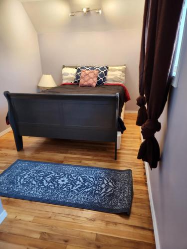 a small room with a bed and a rug at Gateway Place in Winnipeg