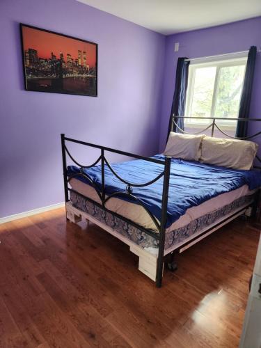 a bedroom with a bed with blue walls and a window at Gateway Place in Winnipeg