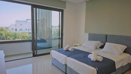 a bedroom with a bed and a large window at STAY Oasis Luxury Villas in Ayia Napa