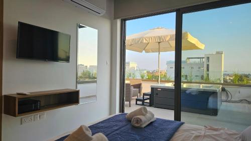a bedroom with a bed and a television and a tub at STAY Oasis Luxury Villas in Ayia Napa