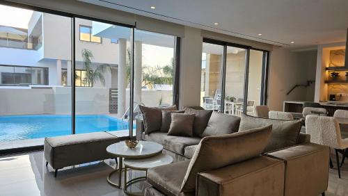 a living room with a couch and a swimming pool at STAY Oasis Luxury Villas in Ayia Napa