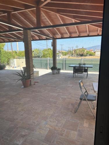 a patio with a table and a chair and a bench at Sunset Villa Apartments Alepokhori in Káto Alepokhórion