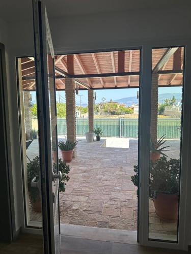an open door to a patio with potted plants at Sunset Villa Apartments Alepokhori in Káto Alepokhórion