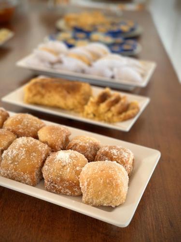 a table topped with plates of donuts and other pastries at Mar à Vista Ilha de Boipeba in Ilha de Boipeba