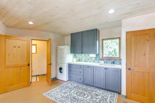 a kitchen with blue cabinets and a white refrigerator at Mtn-View Retreat with Hot Tub in New Mexico! in Arroyo Seco
