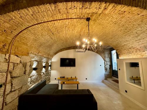 a living room with a stone wall and a couch at Loft de charme en centre ville in Sartène