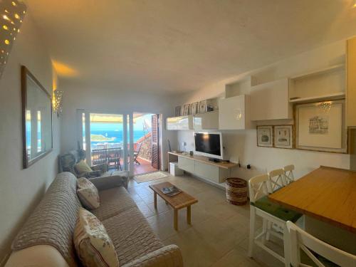 a living room with a couch and a table at Trilocale PUNTA EST Vista Mare in Capo Coda Cavallo