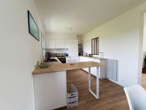 une cuisine avec des armoires blanches et un comptoir en bois dans l'établissement La Dinannaise, à Étel