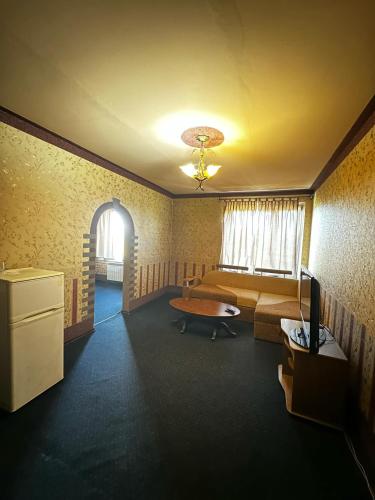 a room with a bed and a table and a television at Motel Ararat in Rava-Rusʼka