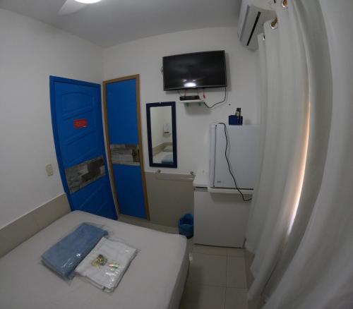 een kleine kamer met een bed en een tv aan de muur bij Hotel Casa Bonita in Campo Grande