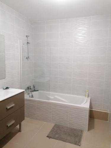 une salle de bain blanche avec une baignoire et un lavabo dans l'établissement APPARTEMENT Villa Galice, à Antibes