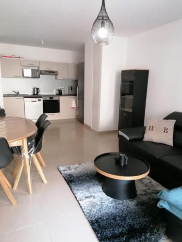 un salon avec un canapé noir et une table dans l'établissement APPARTEMENT Villa Galice, à Antibes