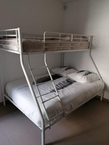 - un lit superposé avec des draps blancs et des oreillers dans l'établissement APPARTEMENT Villa Galice, à Antibes