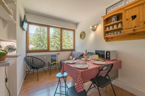 une cuisine avec une table et des chaises dans une pièce dans l'établissement Résidence Grands Montets 524 - Happy Rentals, à Chamonix-Mont-Blanc